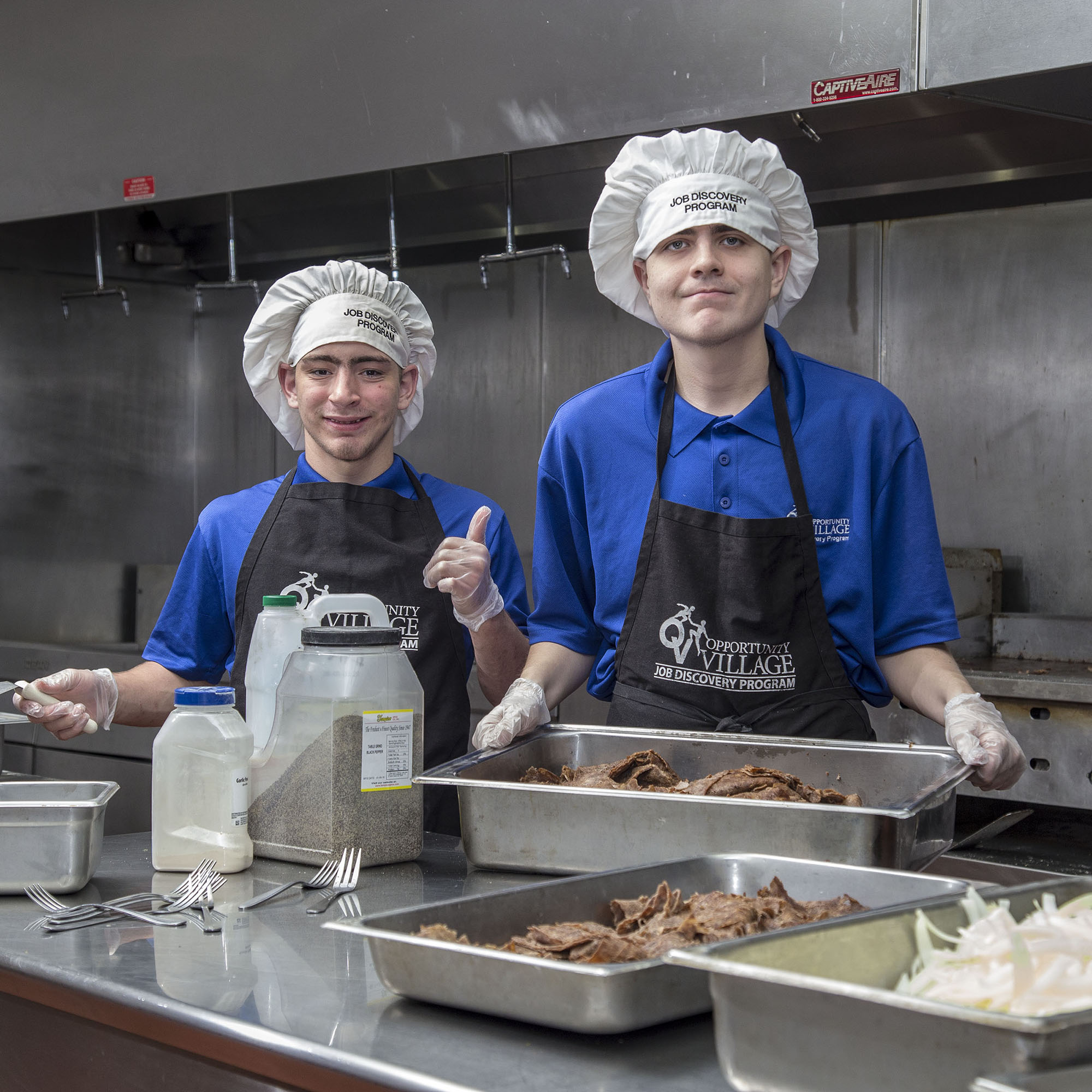 Two young adults working in a commercial bakery.