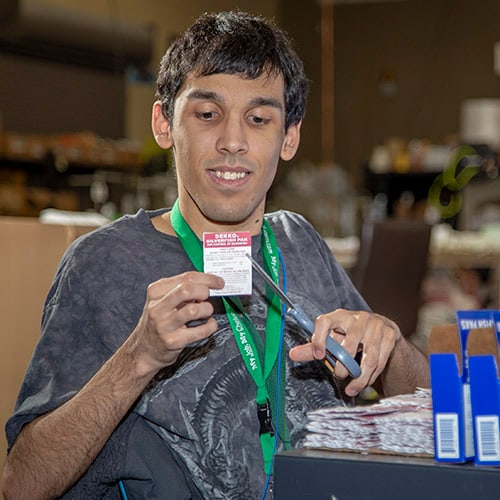 Person using a scissor in an assembly and kitting warehouse.