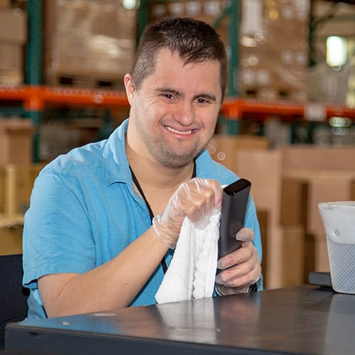 Man cleaning a remote control at work.