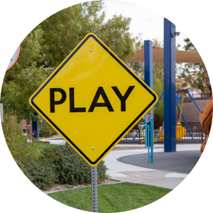 learning-playground_1 Yellow street sign displaying the word "play" at an accessible playground.