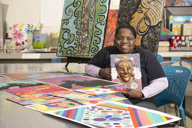 Woman holding art piece.