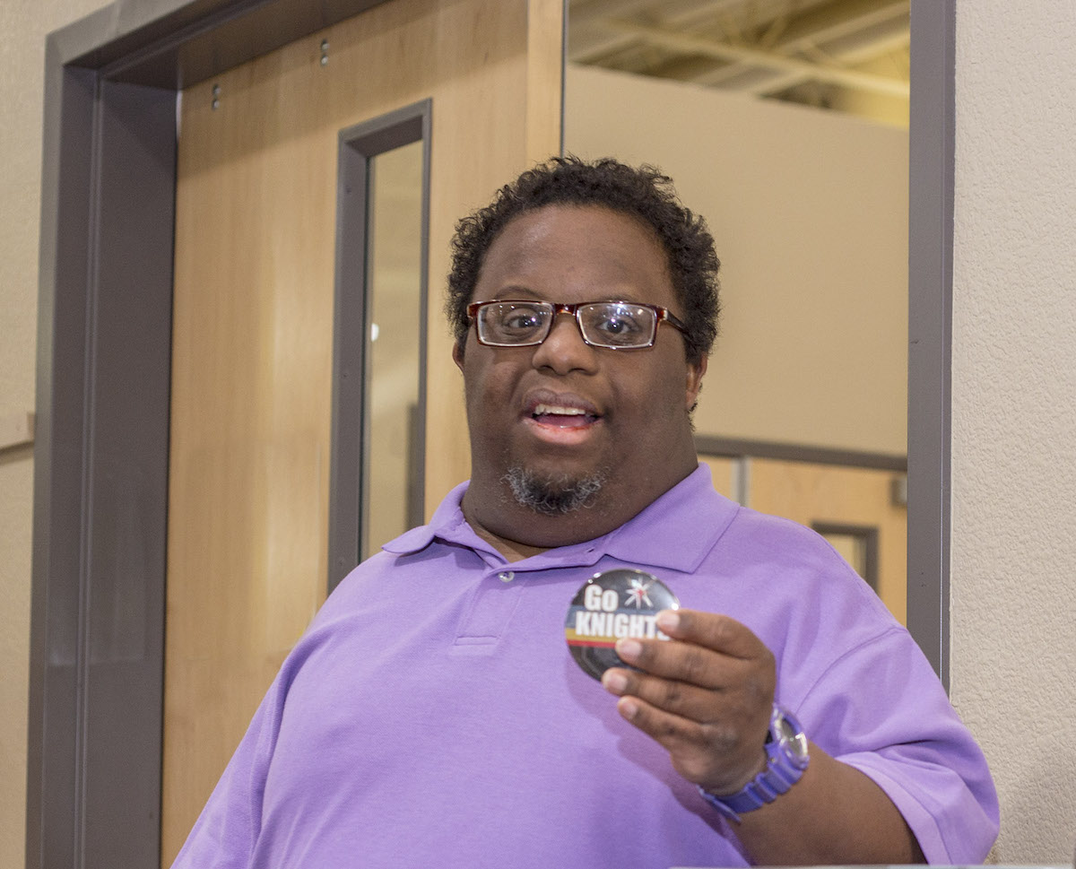 Man holding a promotional button for a sports team.