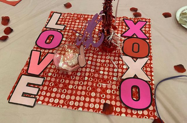 table placemat decorated for valentine's day with hearts and the words "Love" and "XOXO"