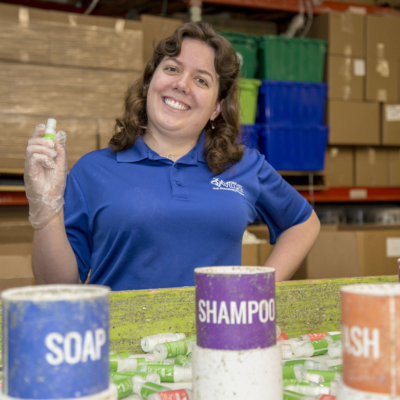 Woman standing in warehouse sorting products.