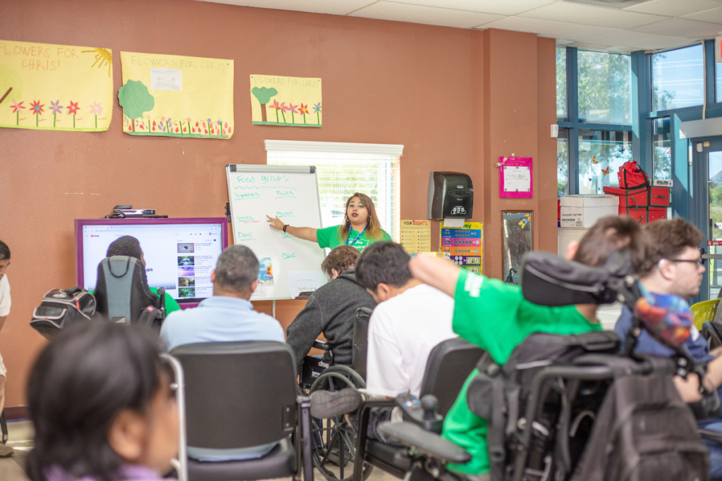 Woman instructing a group of students at a non profit organization.