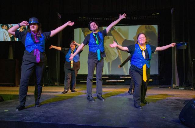 People performing a musical production on stage.