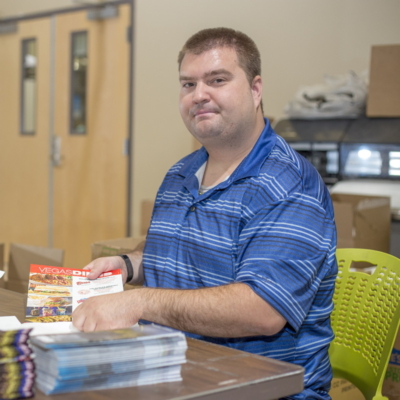 printing-shop Persona sorting printed brochures.