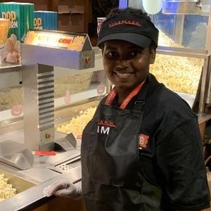 Student worker standing at a concessions stand at a move theater.