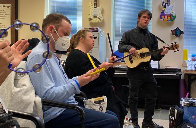 Group of adults playing musical instruments in a day program.