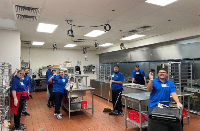 Group of people working in a commercial kitchen.