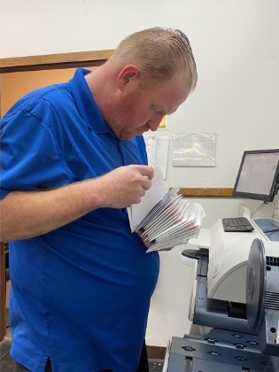 Man sorting envelopes in a mail room.