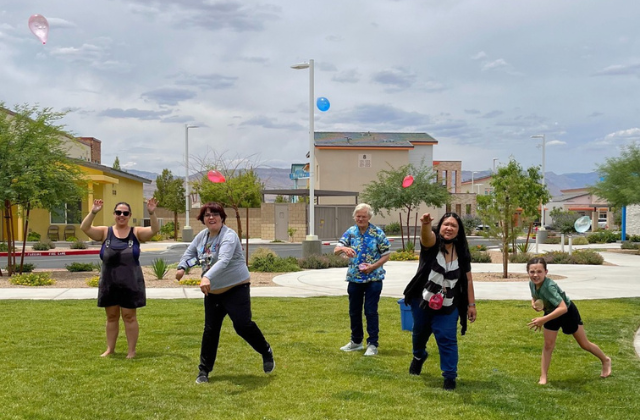 play-therapy-for-adults-with-disabilities-1 Group of people throwing water balloons in the park.