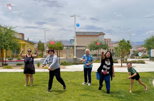 Group of people throwing water balloons in the park.