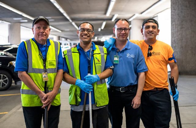 Group of four men working in custodial services.