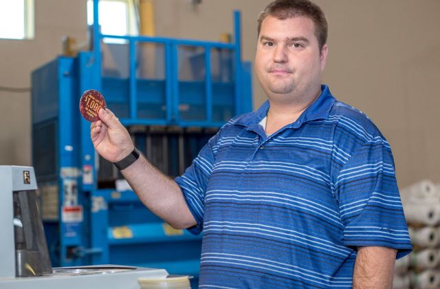 man in blue shirt holding a custom promotional button