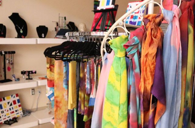 colorful silk scarves hanging on display in a shop