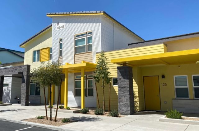 row of white townhomes with yellow trim