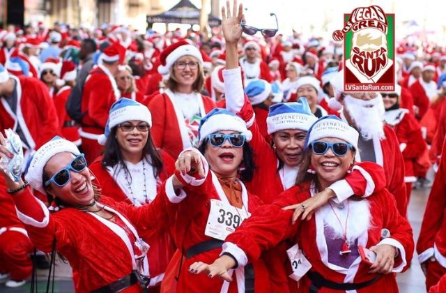 group of people wearing santa suits at a 5k race in downtown las veags