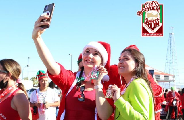 two women taking a photograph of themselves at the las vegas great santa run