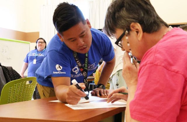 man helping a woman fill out paperwork