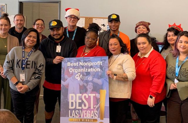 Group of people standing behind a sign that reads 'best nonprofit organization, best of las vegas, gold winner'