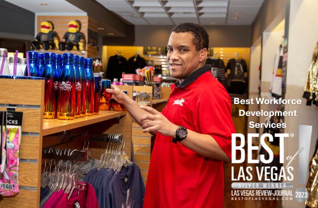 a person in a red shirt standing at a retail display shelf with the words 'best workforce development services, best of las vegas silver winner' on the image